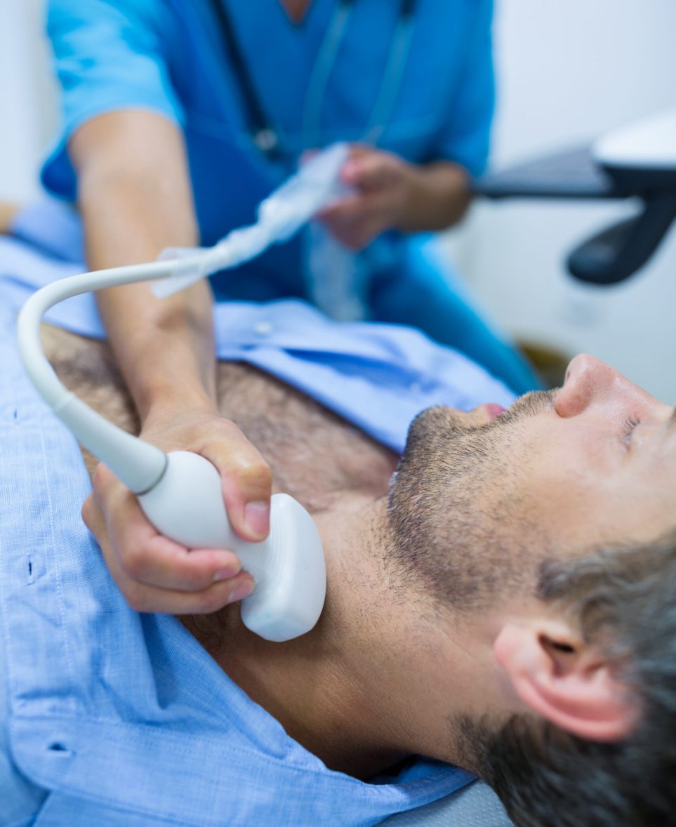 Man getting ultrasound of a thyroid from doctor in hospital